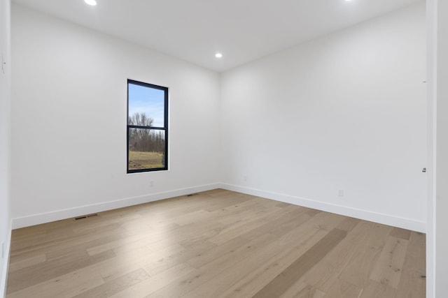 spare room with light wood-style floors, recessed lighting, visible vents, and baseboards