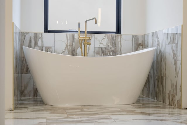 details with a soaking tub and a sink