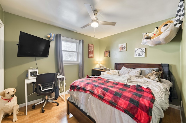 bedroom with light wood-style floors, baseboards, and a ceiling fan