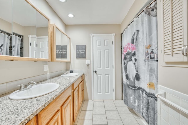 full bath with double vanity, a sink, and tile patterned floors