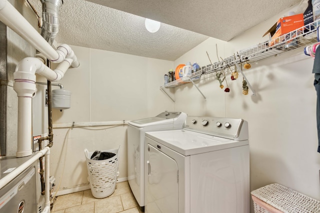 laundry room featuring laundry area, light tile patterned floors, washer and clothes dryer, and a textured ceiling