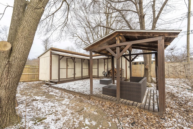 snow covered patio with fence and an outdoor living space