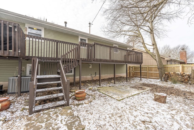 snow covered property with fence, central AC unit, a wooden deck, and stairs