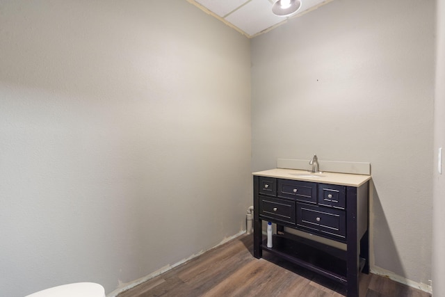 half bath with wood finished floors and vanity