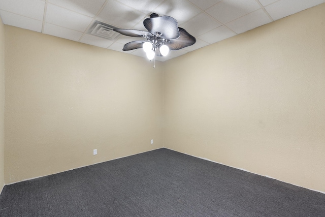 carpeted spare room featuring a drop ceiling and visible vents