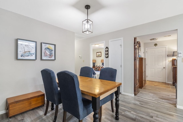 dining space featuring light wood-style flooring and baseboards