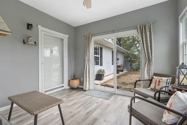 doorway to outside featuring ceiling fan, light wood-style flooring, and baseboards