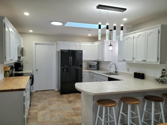 226 Hunt Club Cir, Galena, MO 65656 - kitchen with a peninsula, a breakfast bar, white cabinetry, a sink, and black appliances