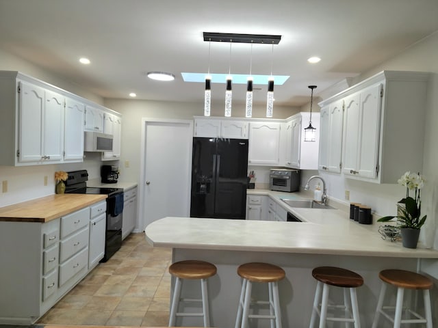 226 Hunt Club Cir, Galena, MO 65656 - kitchen featuring a peninsula, recessed lighting, a sink, hanging light fixtures, and black appliances