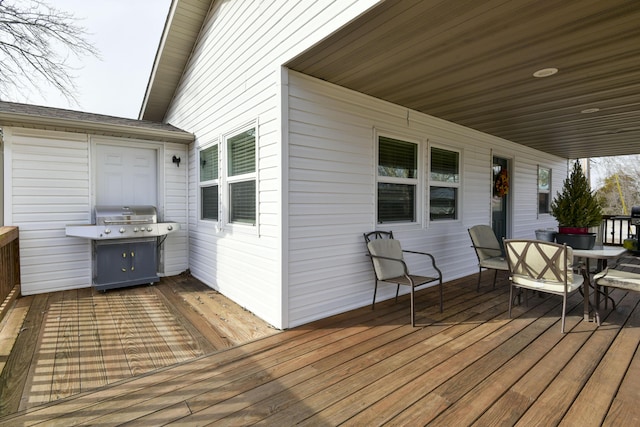 wooden terrace with outdoor dining area and area for grilling