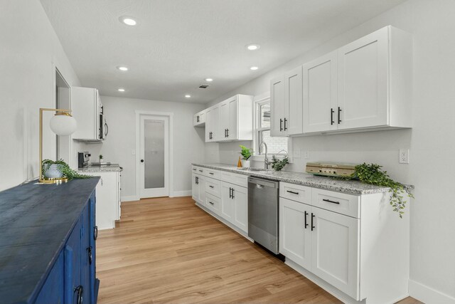 kitchen with a sink, white cabinetry, and stainless steel dishwasher