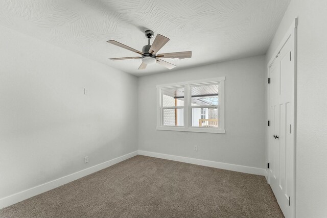 unfurnished bedroom with a ceiling fan, carpet, baseboards, and a textured ceiling