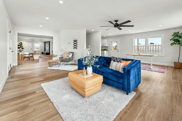 living room featuring light wood-type flooring, a healthy amount of sunlight, baseboards, and recessed lighting