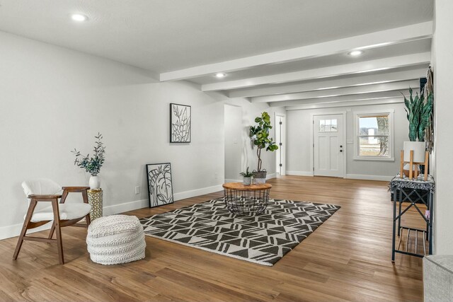 living area with recessed lighting, beamed ceiling, baseboards, and wood finished floors