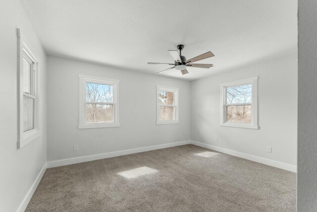 spare room with carpet, a healthy amount of sunlight, ceiling fan, and baseboards