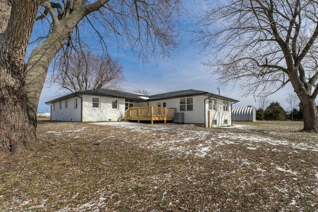 snow covered property with brick siding and a deck