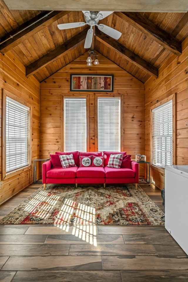 unfurnished living room featuring lofted ceiling with beams, a wealth of natural light, wooden walls, and wood finished floors