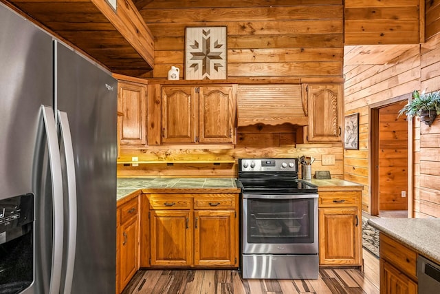 kitchen featuring stainless steel appliances, brown cabinetry, and light wood finished floors