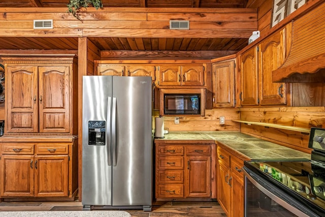 kitchen with tile countertops, visible vents, brown cabinets, and stainless steel appliances