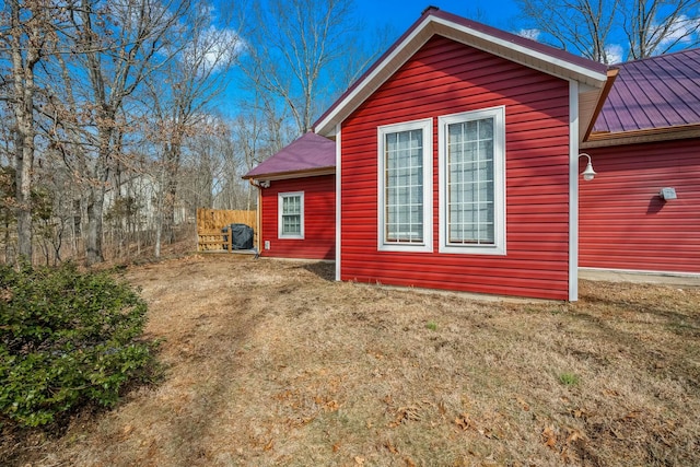 view of side of property with metal roof and a yard