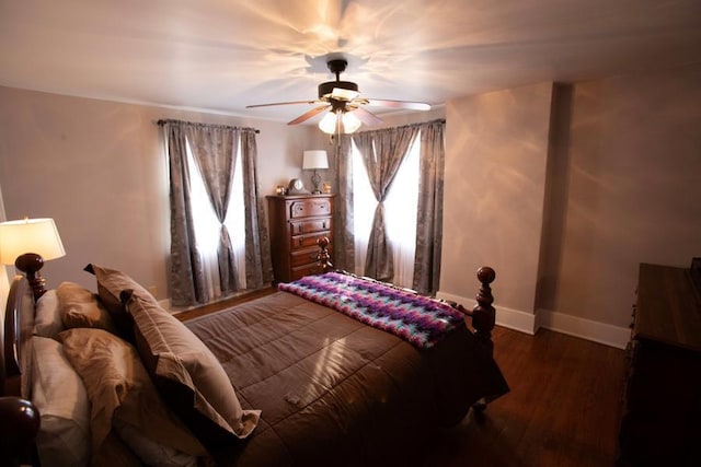 bedroom featuring dark wood-style floors, baseboards, and a ceiling fan