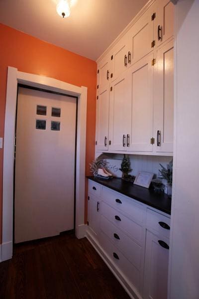 kitchen featuring dark countertops, white cabinets, and dark wood finished floors