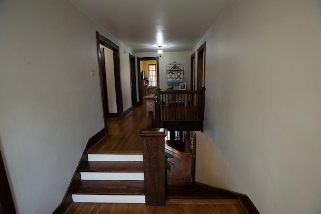 stairway with wood finished floors and baseboards