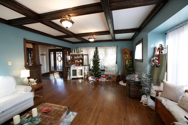 living area featuring a healthy amount of sunlight, dark wood-style floors, coffered ceiling, and beam ceiling