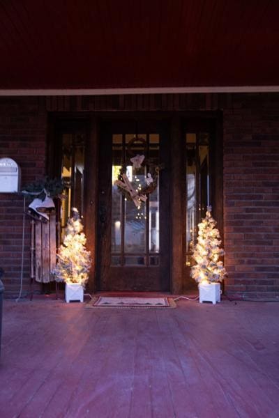 doorway to property featuring brick siding