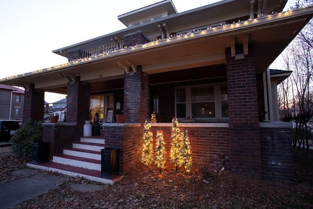 view of front facade featuring covered porch and brick siding