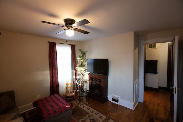 bedroom featuring visible vents, baseboards, a ceiling fan, dark wood-style floors, and a fireplace