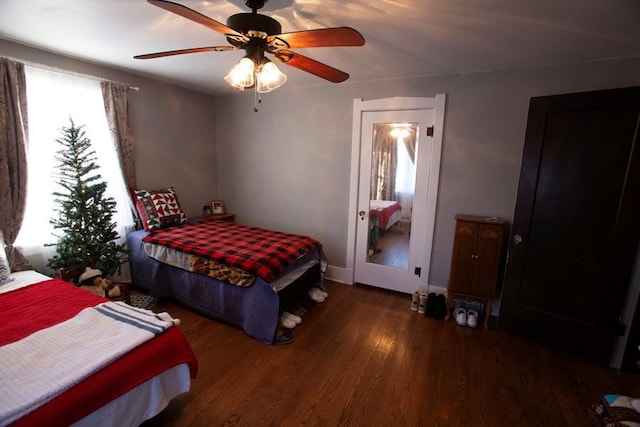 bedroom with dark wood-style floors, baseboards, and a ceiling fan