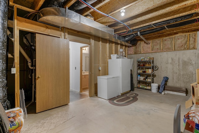 unfinished basement with fridge and freestanding refrigerator