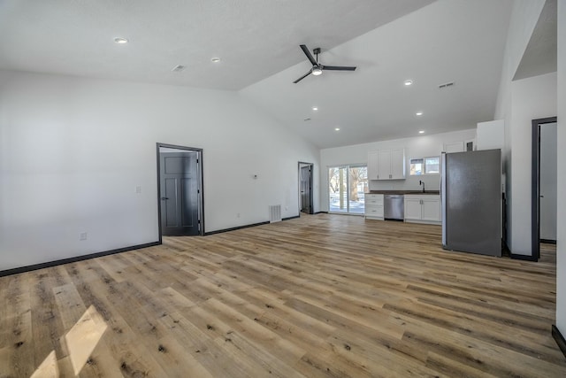 unfurnished living room featuring a ceiling fan, light wood-type flooring, visible vents, and a sink