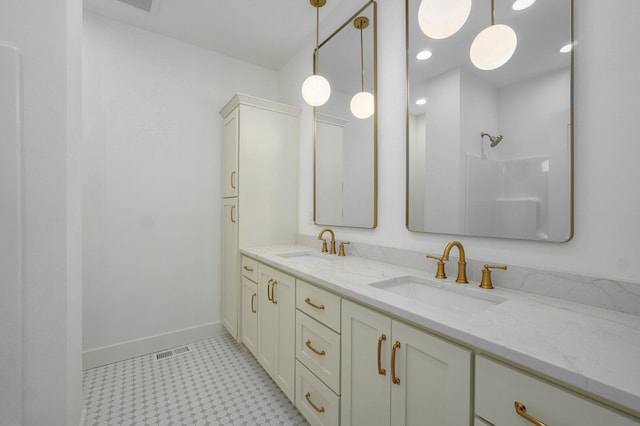 bathroom with visible vents, a sink, baseboards, and double vanity