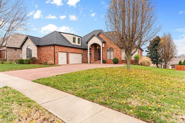 french country home featuring a shingled roof, a front yard, brick siding, and driveway