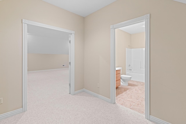 corridor featuring light carpet and baseboards