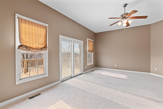 carpeted empty room with ceiling fan, visible vents, and baseboards