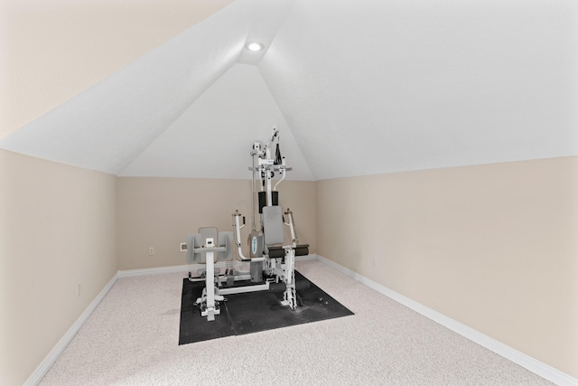 exercise room featuring vaulted ceiling, carpet, and baseboards