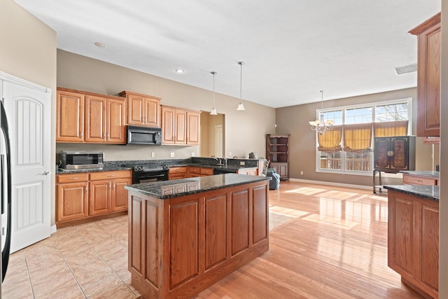 kitchen featuring visible vents, dark stone counters, an inviting chandelier, black appliances, and pendant lighting