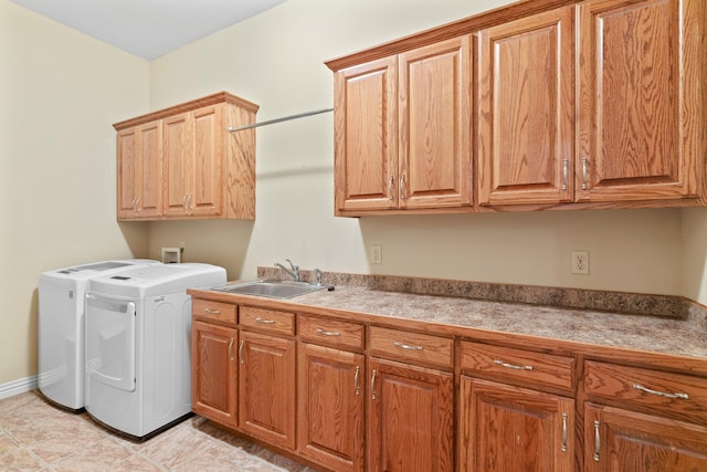 laundry room with baseboards, cabinet space, a sink, and washing machine and clothes dryer