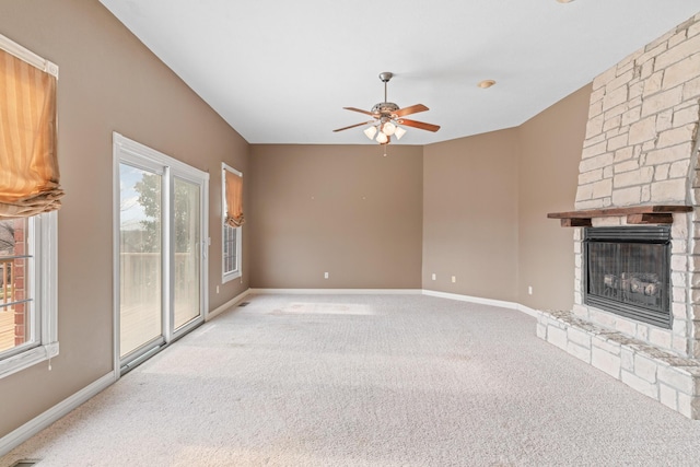 unfurnished living room with carpet floors, a fireplace, a ceiling fan, and baseboards