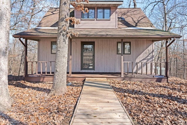 view of front of home featuring a shingled roof and covered porch