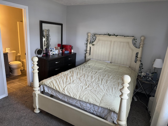 bedroom featuring dark colored carpet, connected bathroom, and dark tile patterned flooring