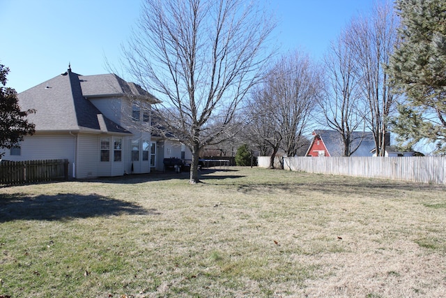 view of yard featuring a trampoline and fence