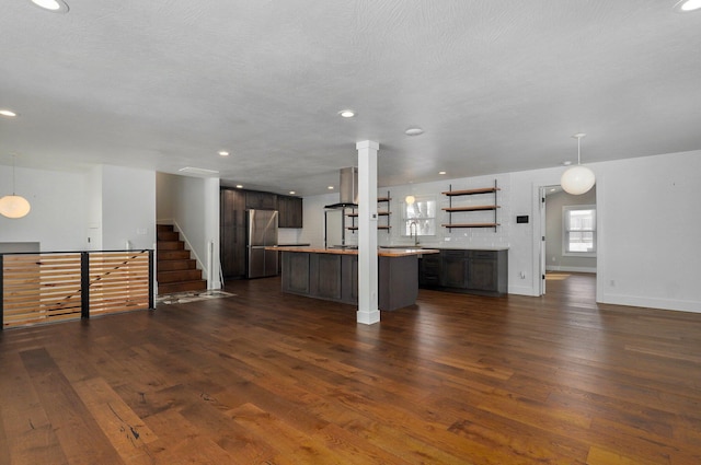 kitchen with pendant lighting, freestanding refrigerator, open floor plan, and light countertops