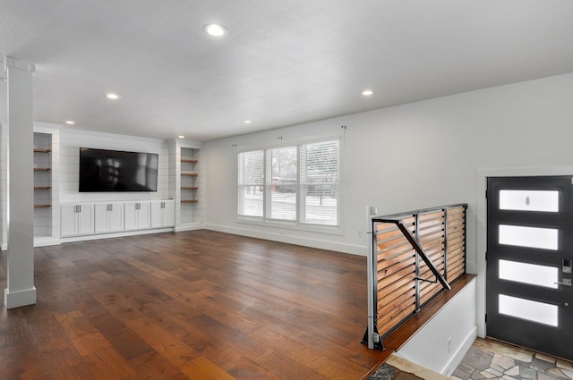 interior space featuring built in shelves, recessed lighting, dark wood-style flooring, and baseboards