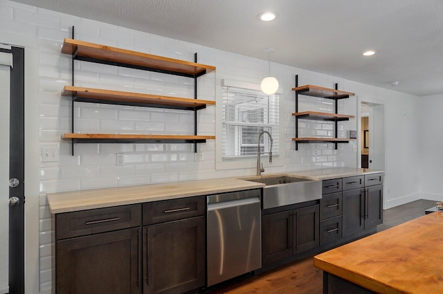 kitchen featuring tasteful backsplash, dishwasher, decorative light fixtures, a sink, and recessed lighting