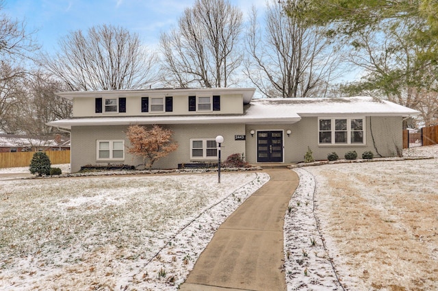 view of front of property featuring french doors, brick siding, and fence