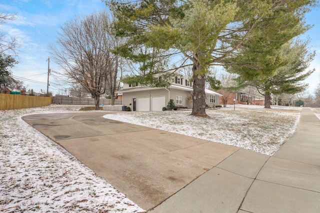 view of front of property with concrete driveway, an attached garage, and fence